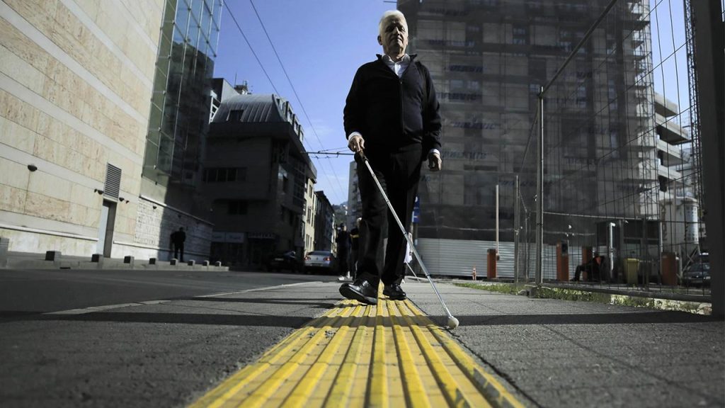 Bastonuyla sarı çizgide yürüyen bir adam